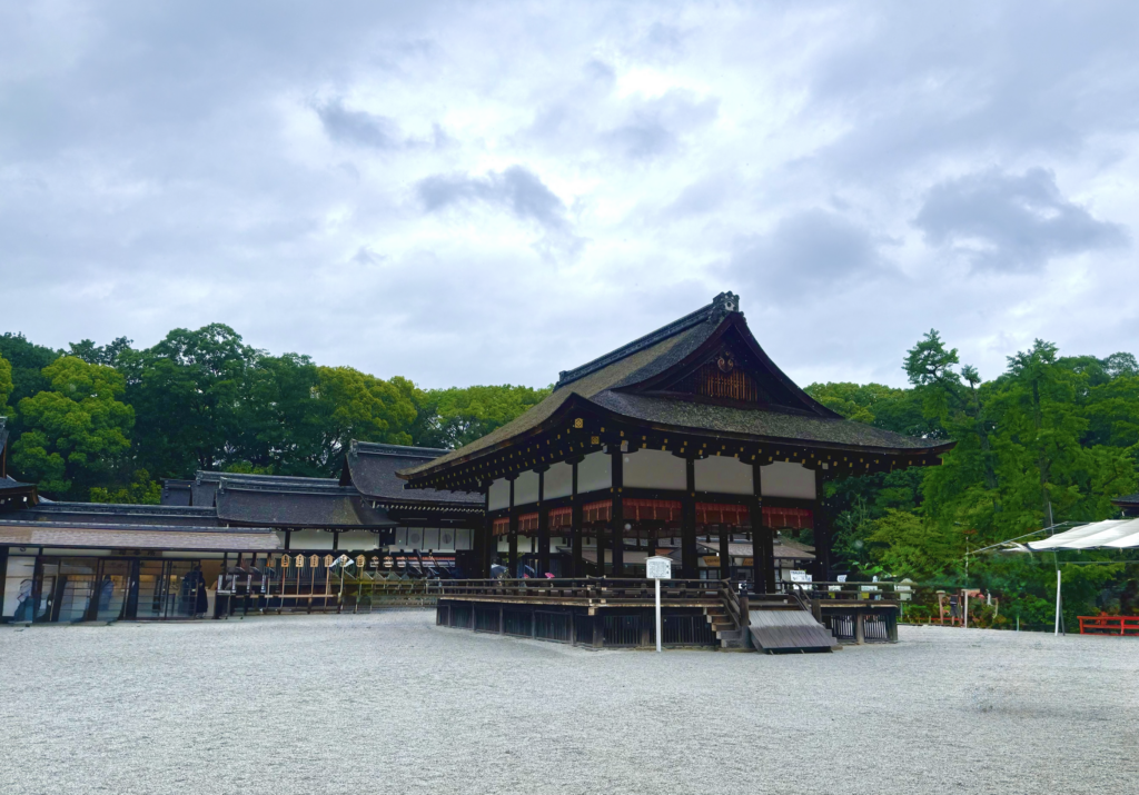 下鴨神社（賀茂御祖神社）の舞殿。曇り空と緑に囲まれた雨の日の境内